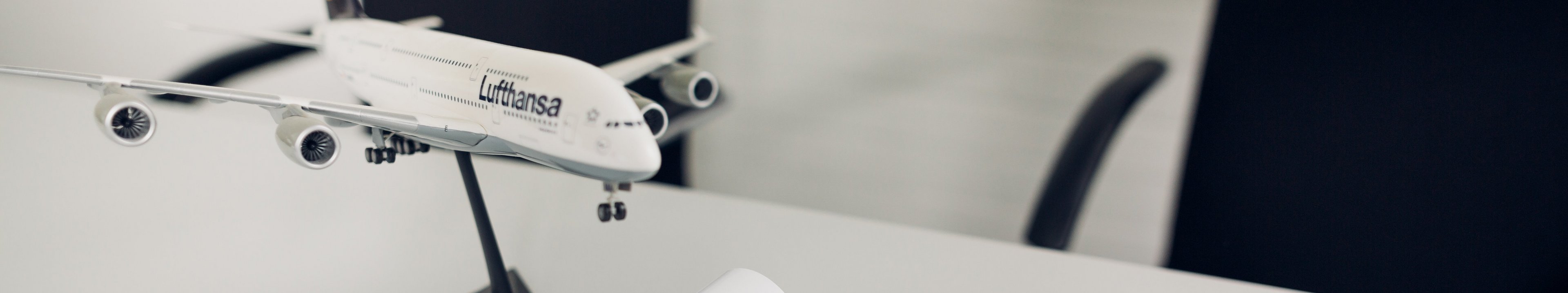 Schreibtisch mit Flugzeug-Model und einer aufgeschlagenen Zeitschrift